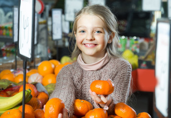 portret of little girl choosing mandarins at store © caftor