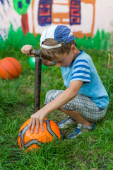 Boy inflates soccer ball pump