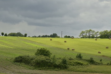 Champs de blé et bottes de foin avant le passage d'une forte averse au Périgord Vert