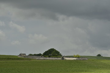 Cimeti&egrave;re rustique et petite colline sous un gros nuage d'orage bien sombre au P&eacute;rigord Vert