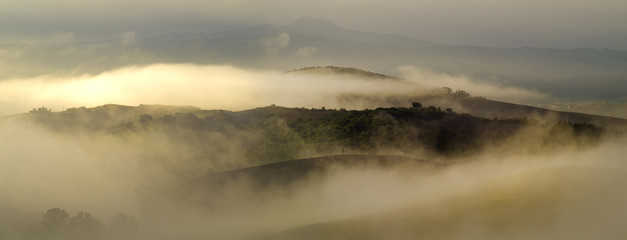Fototapeta premium The morning Tuscan landscape, fog in the valleys 