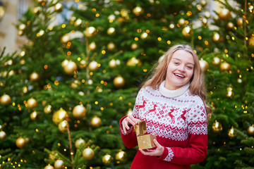 Young woman on a street of Paris decorated for Christmas