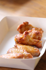 Grilled chicken in a foods white box on a table.