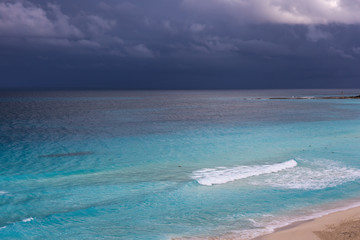 Obraz premium Stormy weather, beautiful turquoise sea under dark blue clouds,
