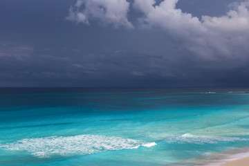 Stormy weather, beautiful turquoise sea under dark blue clouds,