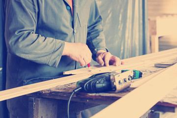 Measuring wooden slot and key boards and drawing with pencil lin