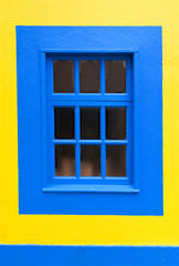 Blue wooden window and yellow wall