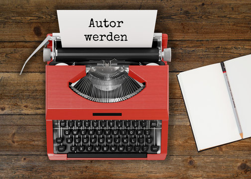 Schreibmaschine mit AUTOR WERDEN-Text und Notizbuch auf Holztisch 