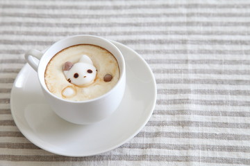 Coffee in white mug with melted cat shaped marshmallow 
