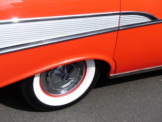 Weißwandreifen und Chromschmuck einer roten amerikanischen Limousine der Fünfziger Jahre bei Sonnenschein beim Oldtimertreffen Golden Oldies in Wettenberg Krofdorf-Gleiberg bei Gießen in Hessen