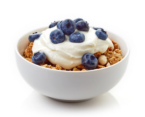 Bowl of whole grain muesli with yogurt and blueberries isolated