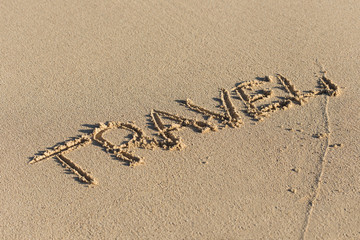 Inscription Travel on sandy beach