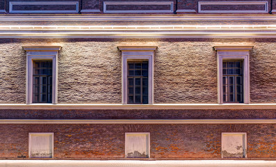 Several windows in a row on night illuminated facade of Central Naval Museum front view, St. Petersburg, Russia.
