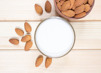 Almond milk with almond on a wooden table.