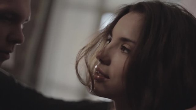 A man pushes a woman against a wall and want to kiss her