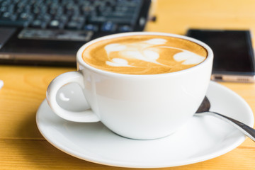 Workplace with laptop notebook and lattte art coffee
