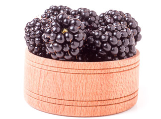 Blackberries in a wooden bowl isolated on white background