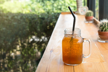 Lemon Iced tea in a glass cup on the wooden table. Interior coffee shop.