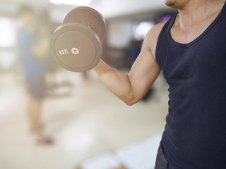 Man training in the gym - dumbbell biceps curl