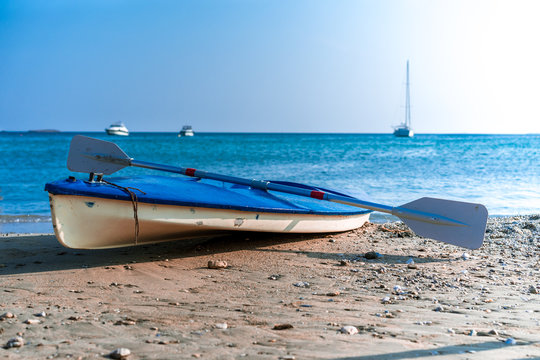 canoe kayak, canoe with oar and yachts in the background on the coast of the Mediterranean Sea. Water Sports. beautiful landscape.small boat with oars