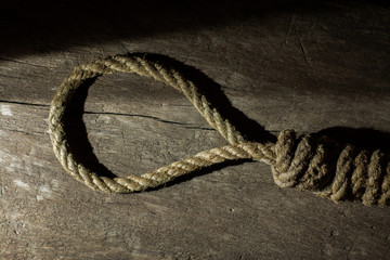 Noose in prison and wall grunge grain texture,Loop of old rope on wall background, Suicide concept...
