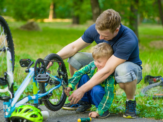 Fototapeta na wymiar father helping his son fix bicycle