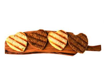 Delicious toast  in form of heart on a wooden board.