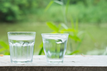 Cool water on wooden desk with Lake background