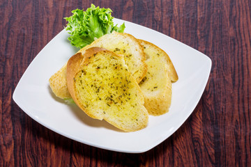 Garlic bread on white plate