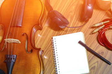 Violin phone notebook on wood background.hipster tone.