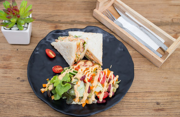 Sandwiches, salads, vegetables, sauce on the wooden floor.