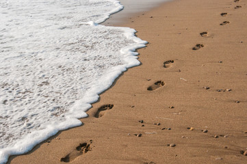 beach, waves and footsteps at sunset time