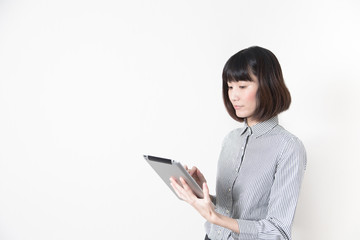 タブレットを触る女性・白バック