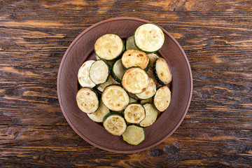 Fried zucchini on the plate, top view