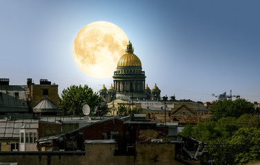 Obraz premium The full moon over Saint Isaac's Cathedral and the city centre d