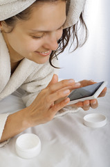 girl in a bathrobe looking at phone