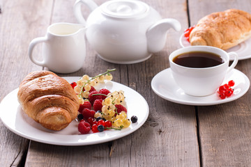 Delicious breakfast with fresh croissants and ripe berries.