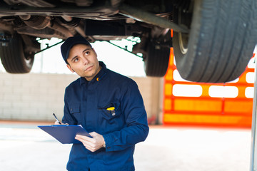 Auto mechanic working on a car in his garage