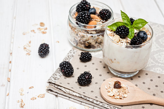 homemade yogurt with muesli amd berries on wooden background