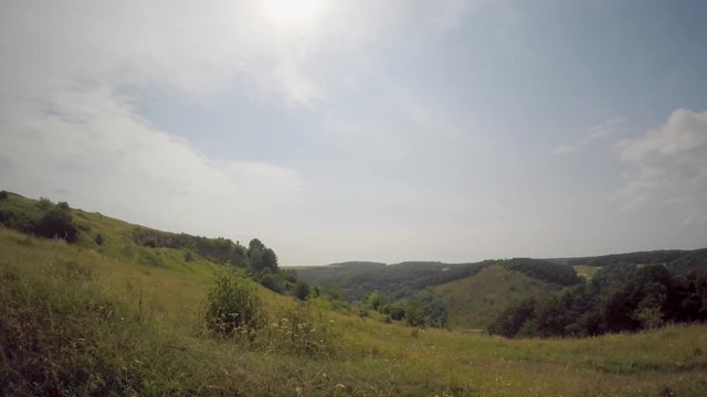 Timelapse of clouds running above summer feild