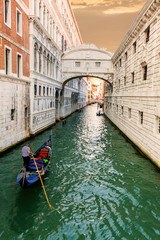 Fototapeta na wymiar Bridge of Sighs in Venice at sunset with a floating past gondola. Travel Italy.