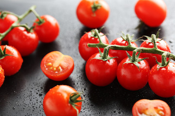 Cherry tomatoes branch on a black background