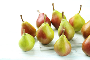 Ripe pears on white wooden table