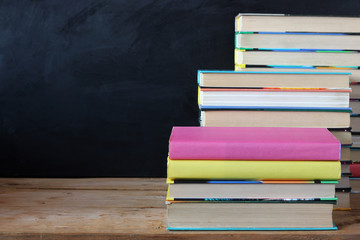 Books in stacks in the background of a school blackboard.