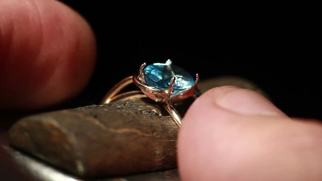 The jeweller is setting a precious stone.