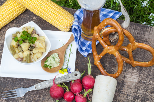 Imbiss mit Brezeln, Bier und Kartoffel-Bohnensalat, Makro von oben 