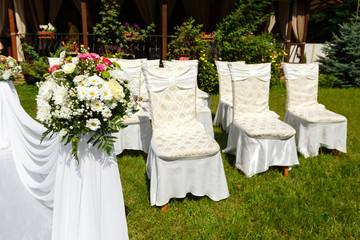 Wedding ceremony decorations . Flowers and chairs close up