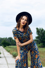 fashion outdoor portrait of a beautiful brunette woman dressed i