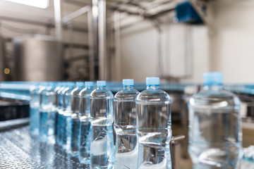 Water factory - Water bottling line for processing and bottling pure spring water into small bottles. Selective focus.