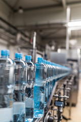 Water factory - Water bottling line for processing and bottling pure spring water into small bottles. Selective focus.